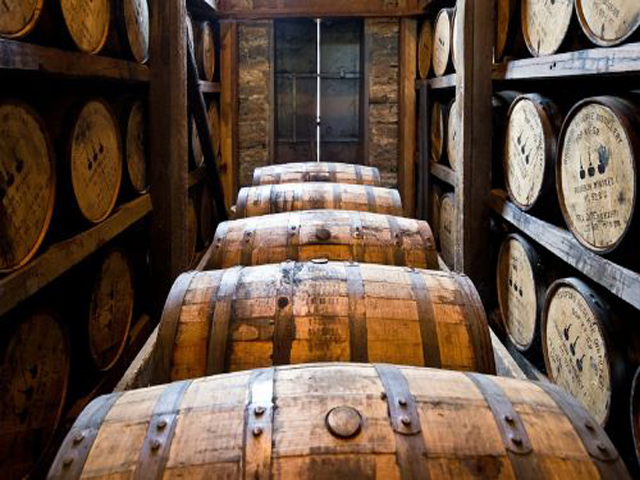 Wooden barrels are shelved on either side of a row of barrels in the middle