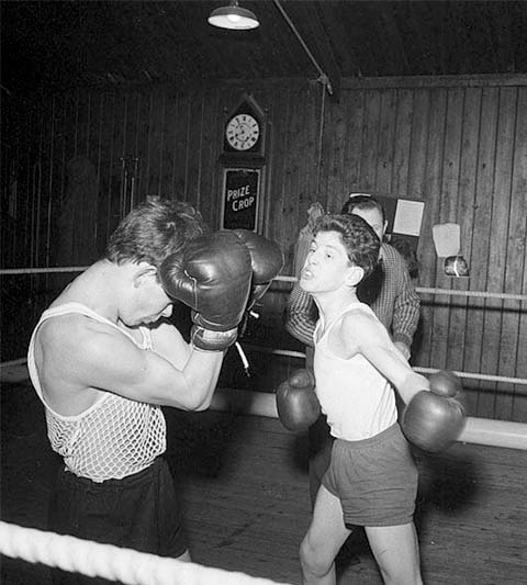 Black-and-white photo of two teens boxing in a ring.