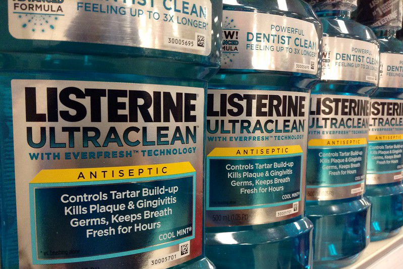 A facing row of 4 Listerine bottles, close-up.