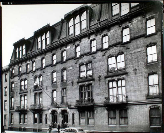 A really old 5-story apartment building in black-and-white.