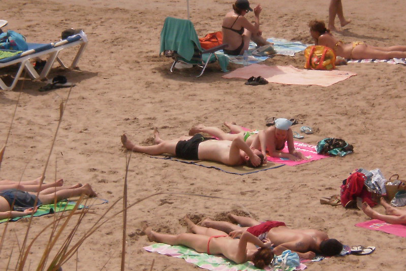 An elevated view of people lying on a beach.