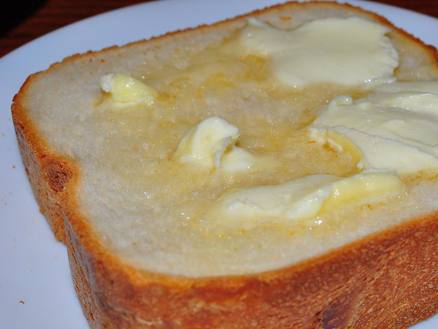 A slice of fresh bread with melting butter