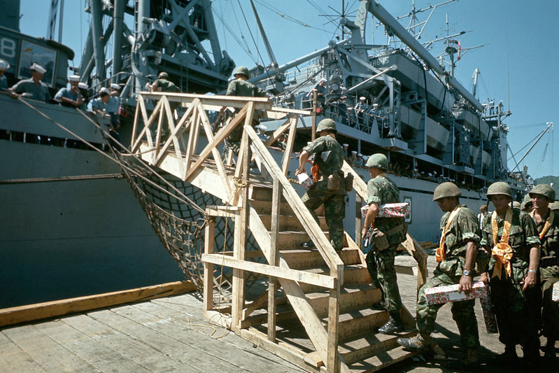 Soldiers climb up a ramp to a ship