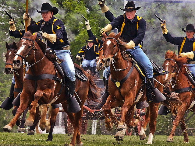 Gunpowder and dirt fly as the 1st Cavalry Division horse detachment make their traditional 'cavalry charge' to conclude the 1st Air Cavalry Brigade's color casing ceremony, March 25, at Cooper Field, Fort Hood, Texas.