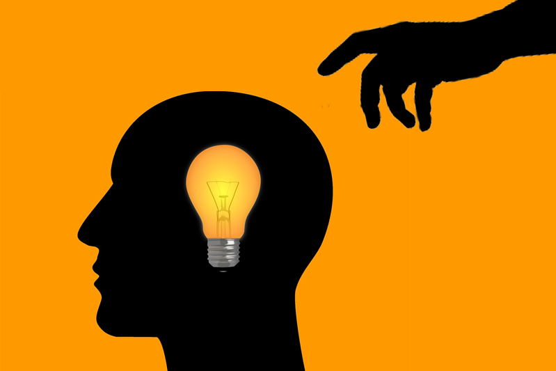 Pumpkin yellow background showcases the silhouettes of a man's head in profile and a hand reaching out to grab the light bulb inside the man's head