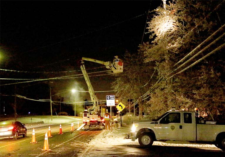 A cold night scene with a crewman in a cherry picker fixing downed wires.
