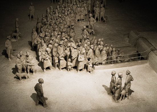 A crowd of people being guided into an underground gas chamber