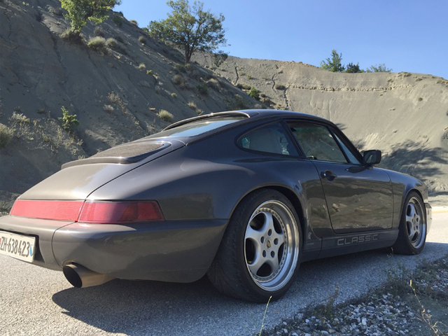 A three-quarter profile of a dusty, gray Porsche 911 classic