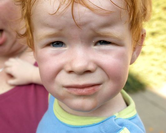 Close-up of an unhappy little boy's face