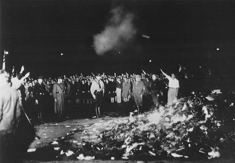 A black-and-white photograph of Nazis burning books