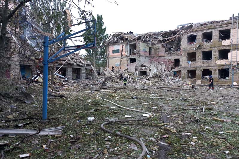 Debris-strewn schoolyard with destroyed buildings