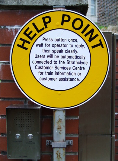 A sign at a self-service railway station explains appropriate phone behavior