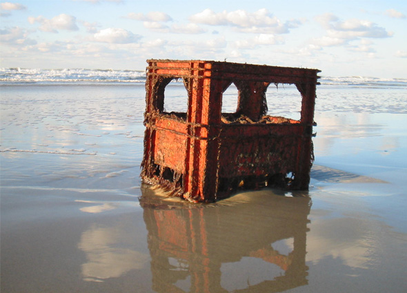 A red plastic milk crate washed up on a beach