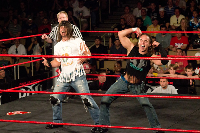 Two guys in ripped jeans and fringed T-shirts taunt the crowd from inside a boxing ring