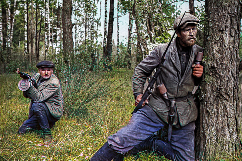 The partisan on the left is carrying what appears to be a Soviet PPD-40 submachine gun. His companion is equipped with a Mosin rifle (with factory bayonet), plus German bayonet/dagger (on waistband) and two RGD-33 grenades.