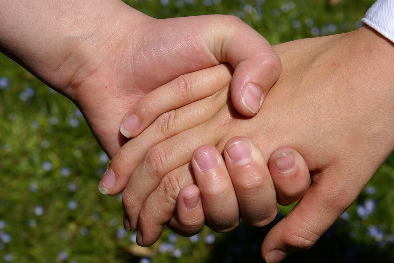 A close-up of two hands holding each other