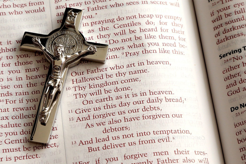 A rosary sits atop an open bible