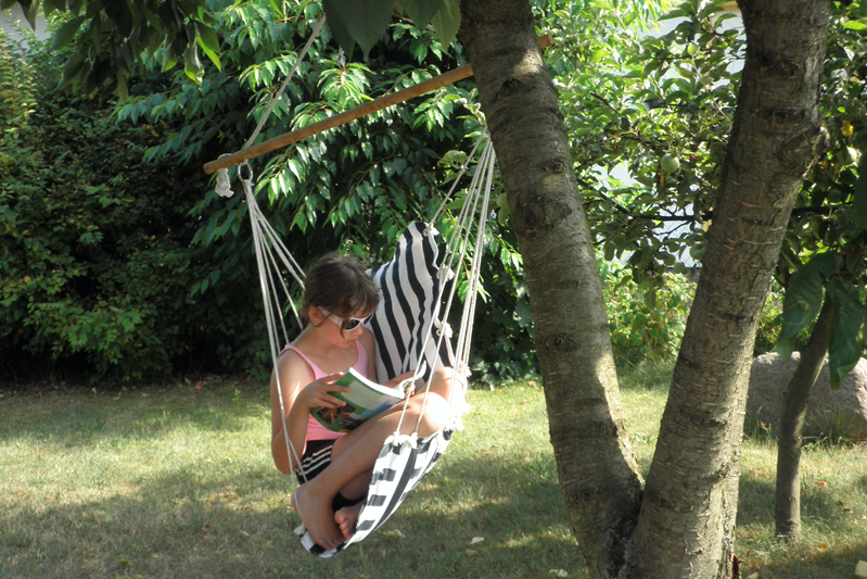 Girl reading in hammock under the trees