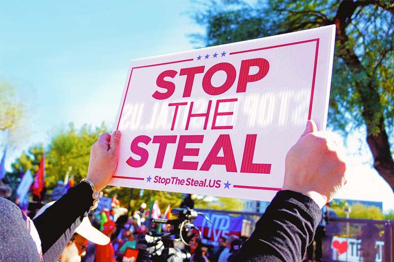A person holding up a sign stating Stop the Steal.