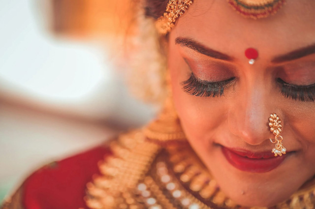 An Indian woman with head downcast.