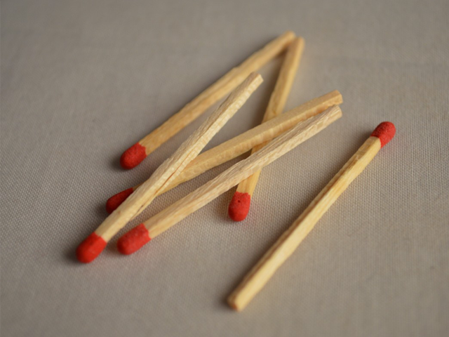 Six wooden matches on a gray background