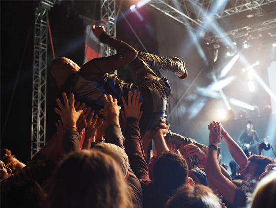 Rock concert with a body surfing over the crowd