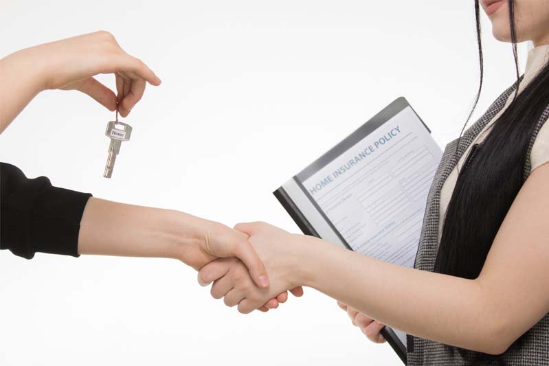 A handshake between women with one handing over the keys.
