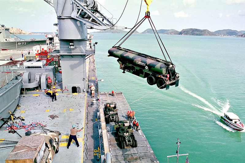 Sailors and Marines guide a tanker trailer as it is lowered over the side of the SS Gopher State (TACS 4) to a lighter craft in Sattahip, Thailand, on May 12, 1998, for use in Exercise Cobra Gold '98. Cobra Gold '98 was part of a continuing series of U.S.-Thai military exercises designed to ensure regional peace and strengthen the ability of the Royal Thai Armed Forces to defend Thailand. The training includes joint combined air, land and sea operations. Cobra Gold is the largest strategic mobility exercise involving the U.S. Pacific Command forces this year.