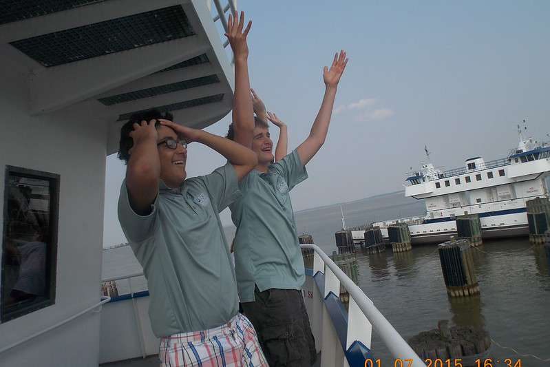 Two distraught men standing in the stern of a ferry