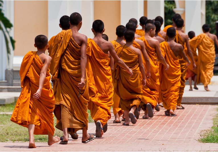 A group of Buddhist monks return to their quarters on the grounds of Wat Niwet Thammaprawat near Ayutthaya, Thailand.