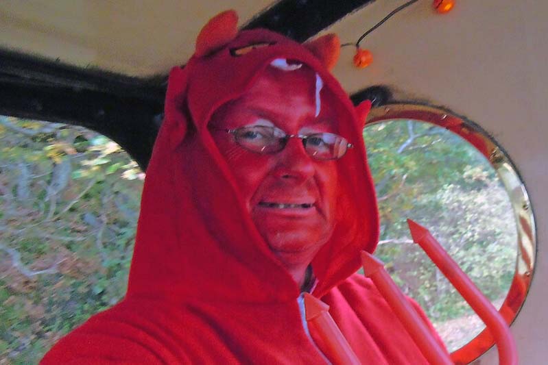 Man painted himself red and wears a fleece devil costume.