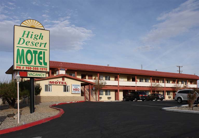 A red-and-cream two-story building with a huge sign on the left.