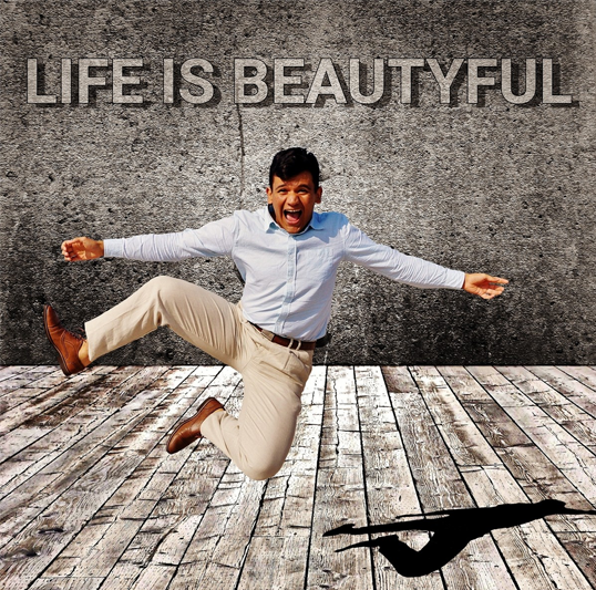 Man in khakis and pale blue button-down shirt kicking his heels up in joy on a wooden floor against a granite background in which Life is Beautyful is engraved.