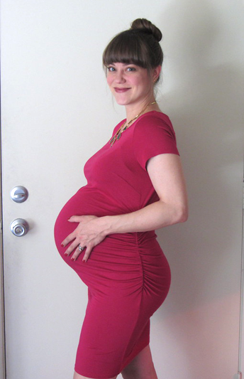 Profile of a very pregnant woman in a deep fuchsia dress
