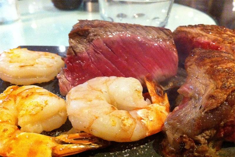 A close-up of medium-rare steak and shrimp.