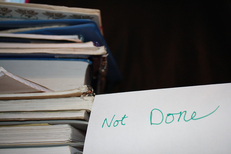 A pile of books on the left with a note saying not done on the right