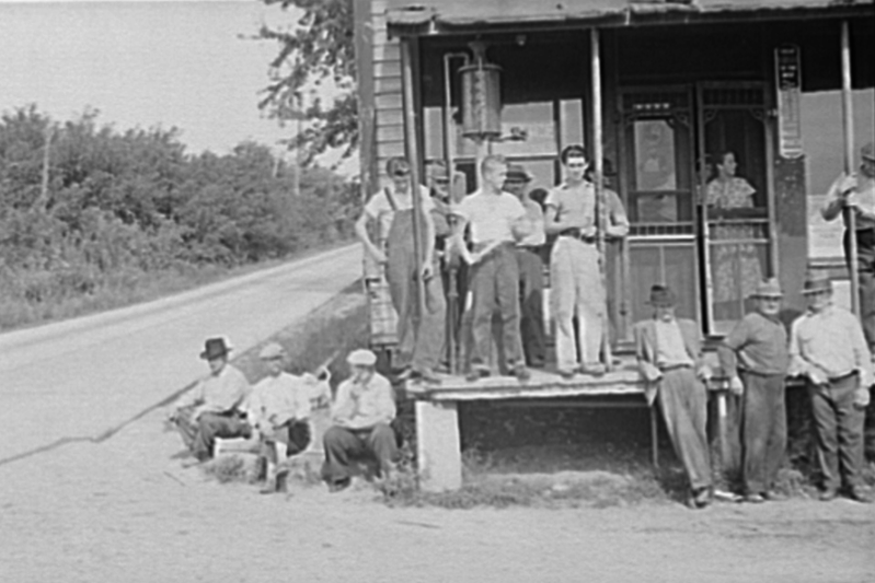 A black-and-white photograph of a group of people posing around a post office