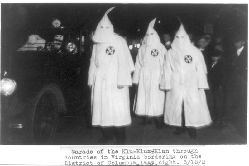 Three members of the Ku Klux Klan at night