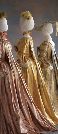 The backs of three colorful court dresses displaying the suspended back panels.