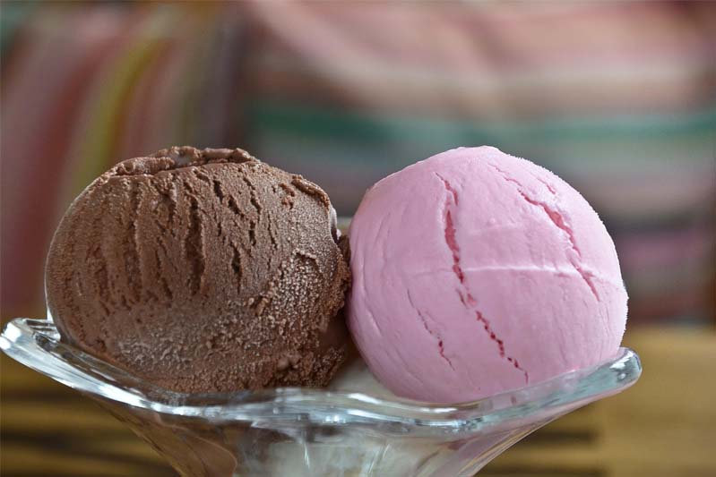 A scoop of chocolate and a scoop of strawberry ice cream