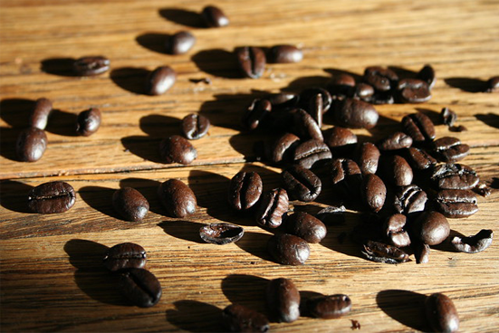 Close-up of coffee beans scattered on a wooden table top