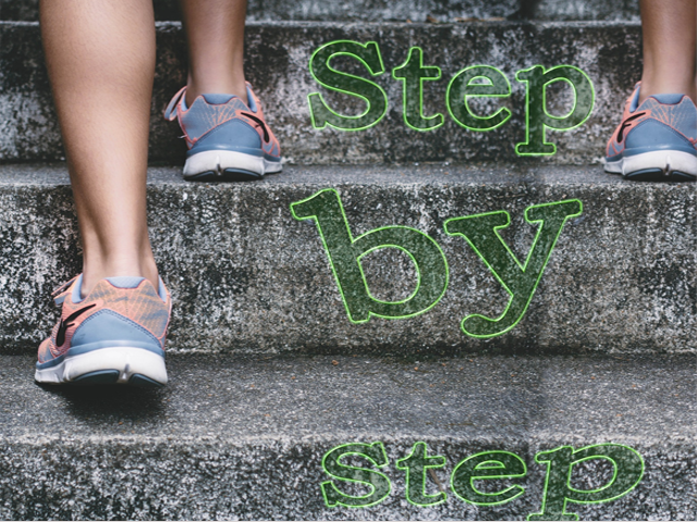 Three bare legs in peach and blue sneakers walk up stone steps with a green sign stating Step by Step between them