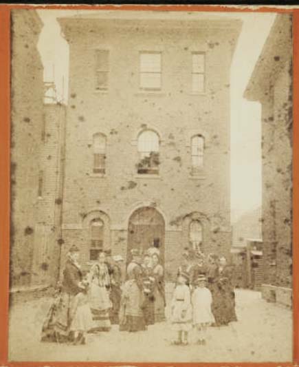 An old, faded picture of a three-storey building from between 1865 and 1885