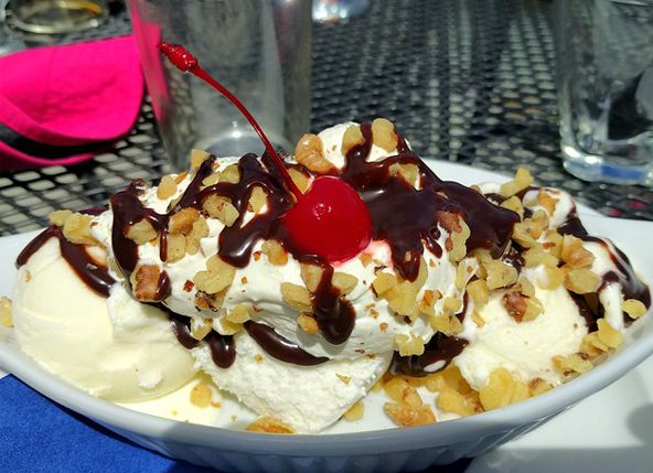 An ice cream sundae topped by a cherry