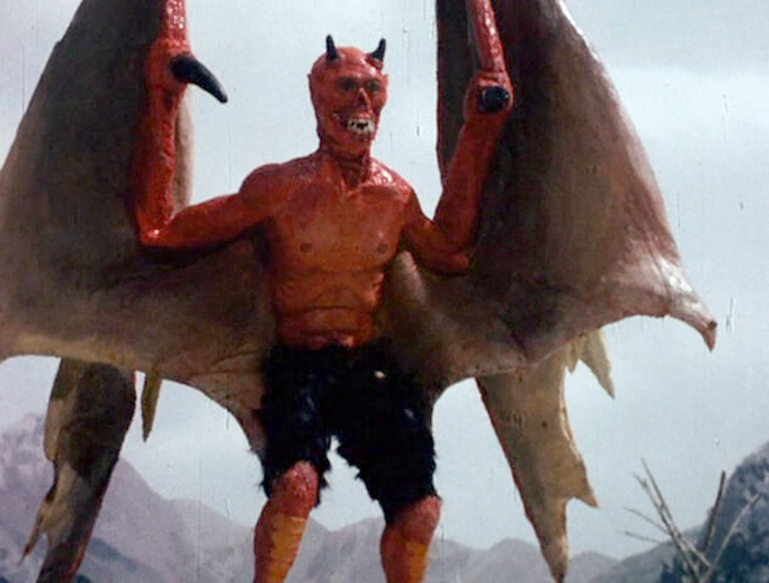 A red demon, all jaggedy with wings on a mountaintop