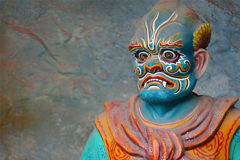 A character from Haw par villa with elaborate face makeup.